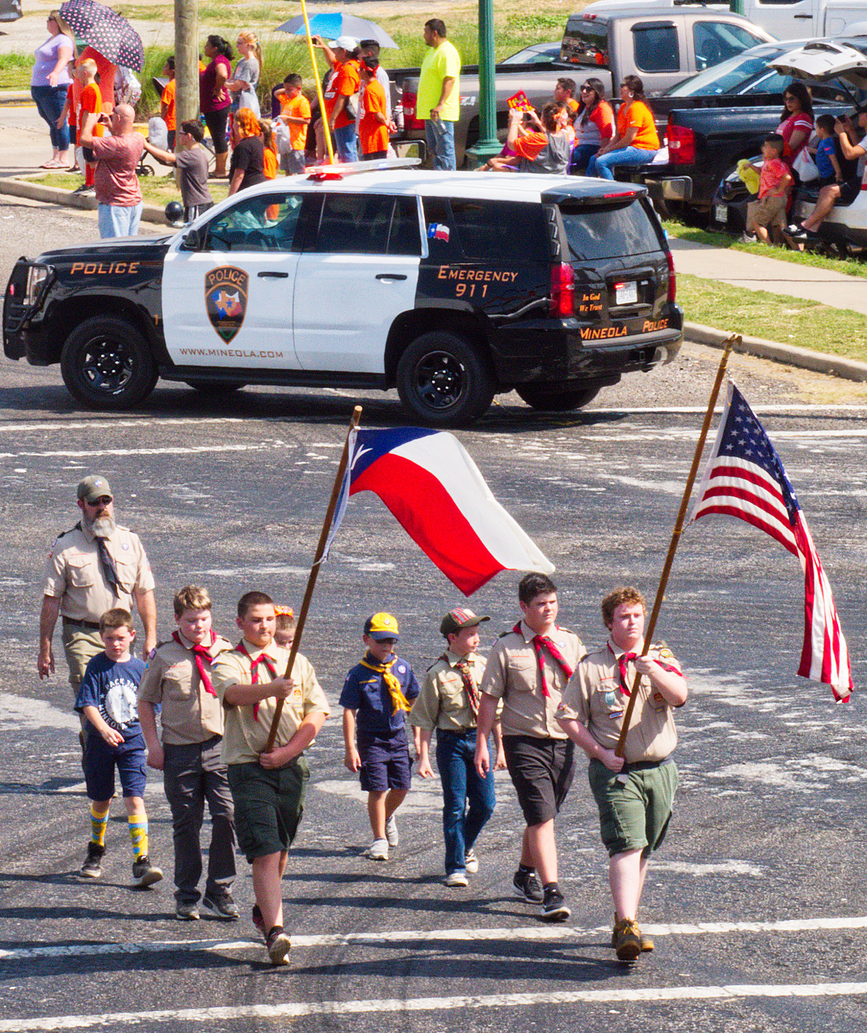 Mineola Scouts carry the United States and Texas flags in the homecoming parade Friday afternoon.
